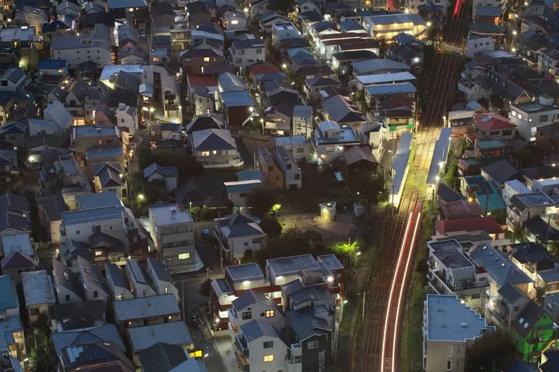 夕暮れの街を走る電車と住宅地